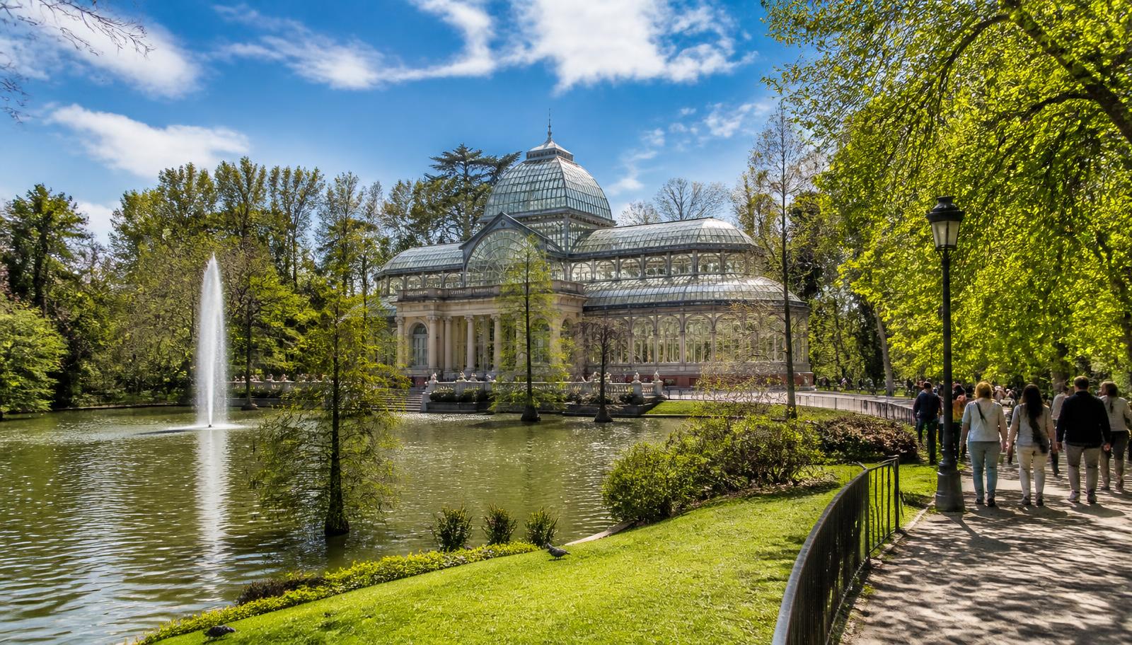 Palacio de Cristal del Parque del Retiro junto al estanque en un día soleado
