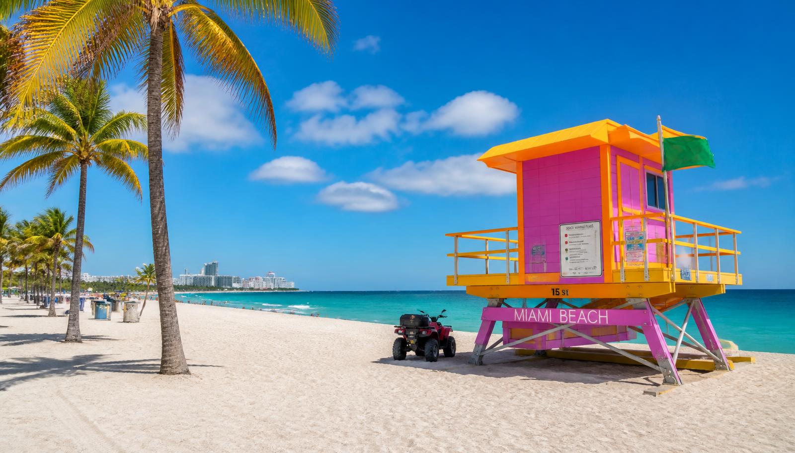 Playa de Miami Beach con arena blanca, agua turquesa y una caseta de socorrista de colores